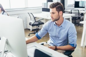 handsome young businessman using desktop computer in office
